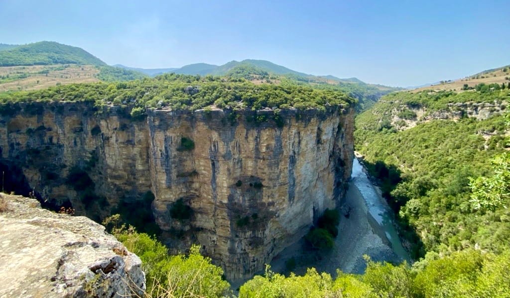 A towering cliff near a river in Albania