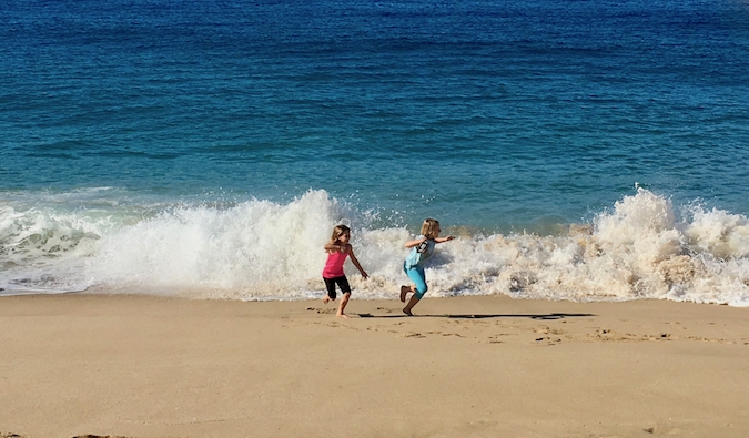 Two young traveling kids having fun at the beach