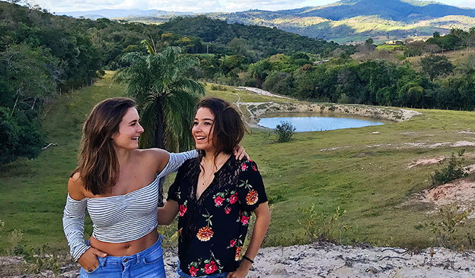 Celinne da Costa and a new friend posing for a photo in front of a scenic landscape
