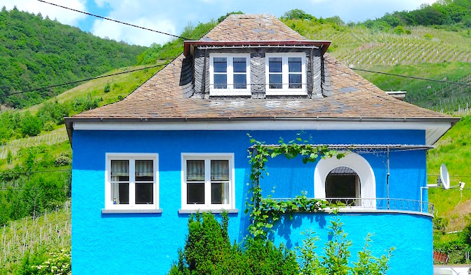 A bright blue villa surrounded by vineyards