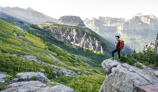 A solo female traveler hiking in beautiful rural Montana, USA wearing a travel backpack