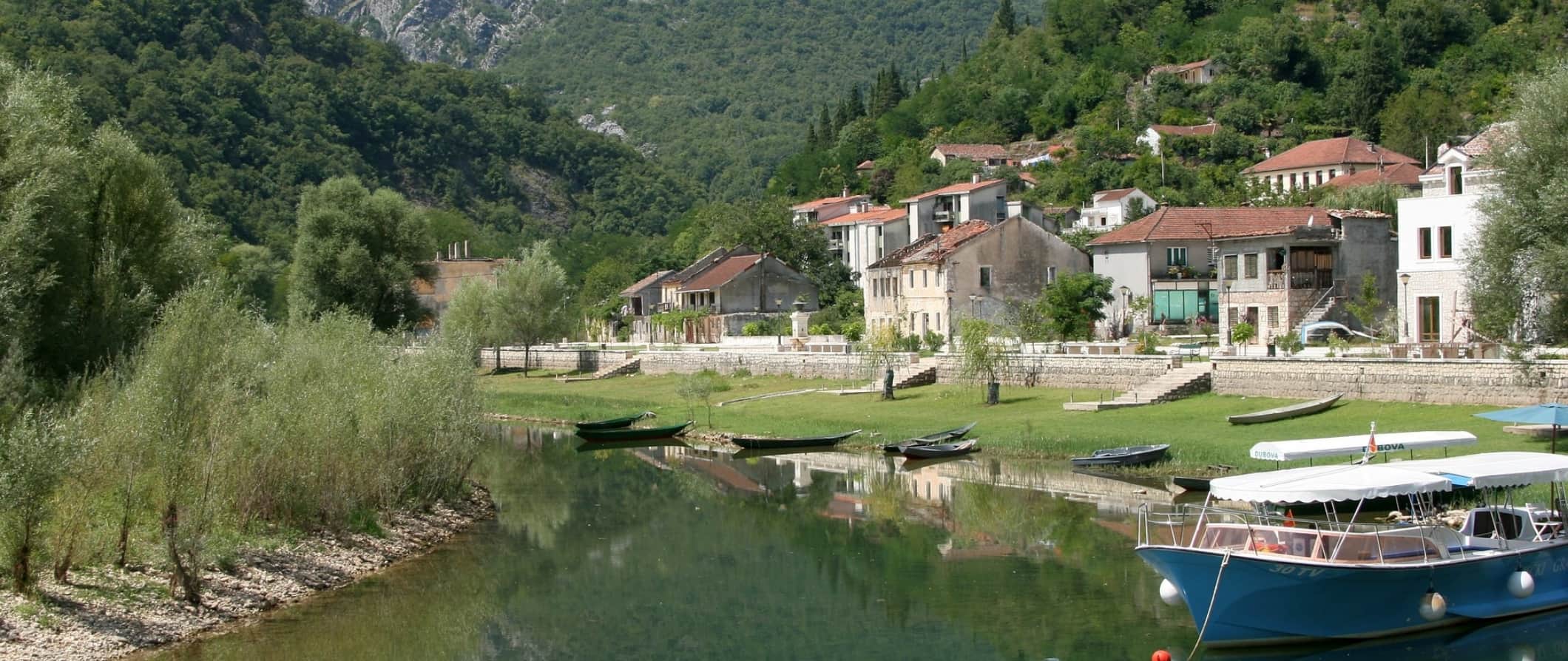 A small village surrounded by trees on the banks of a river in Montenegro