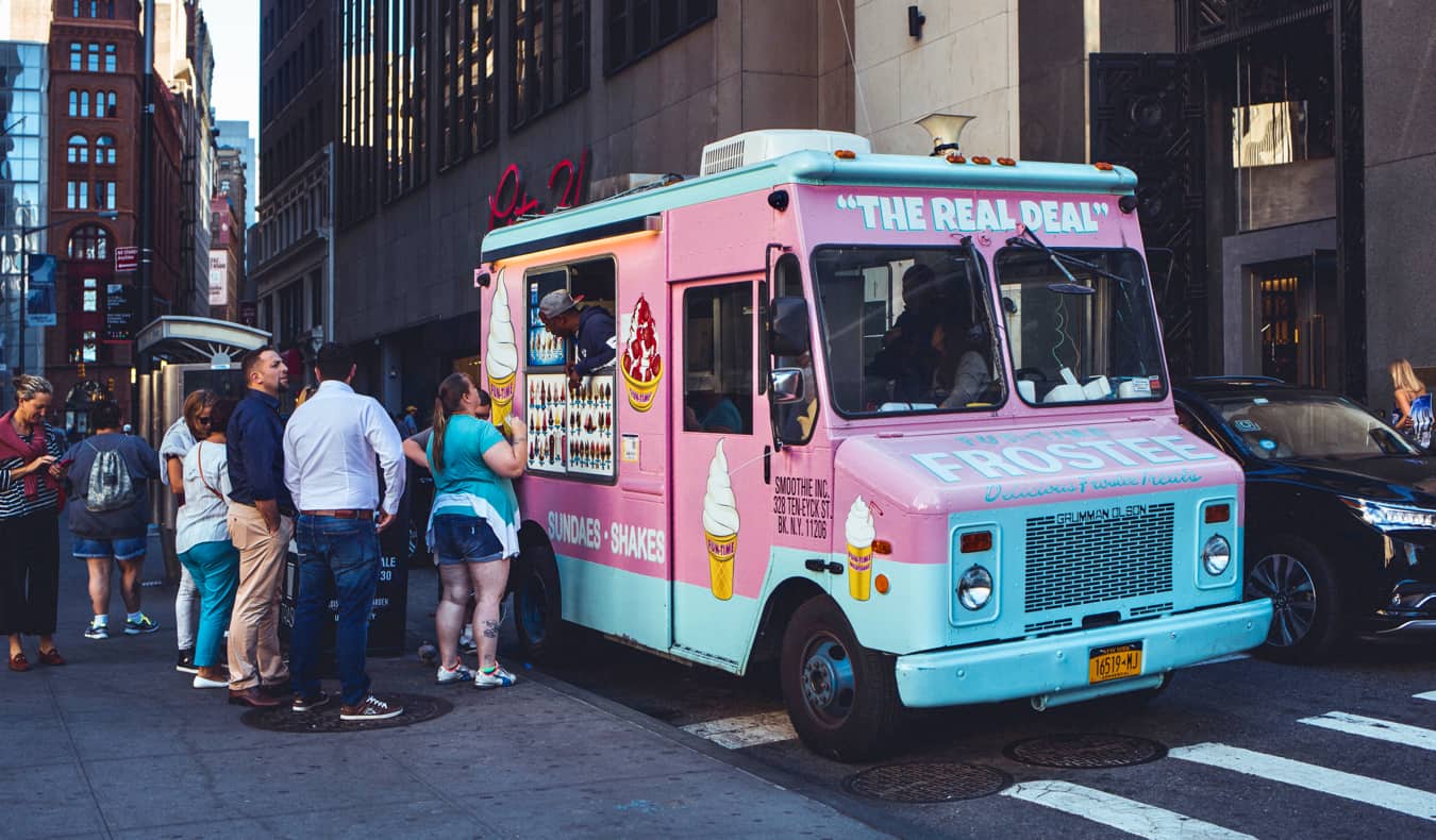 a pink Real Deal food truck busy serving up food in NYC