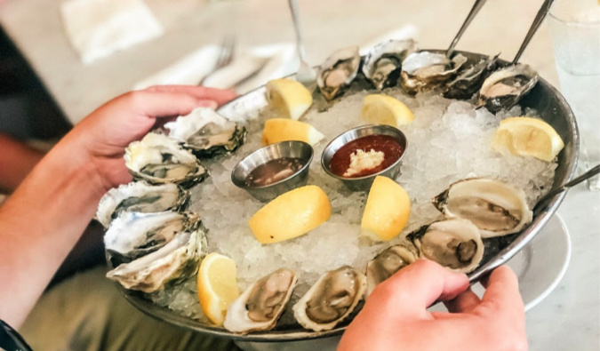 oysters being served to a table in a busy restaurant in NYC, USA