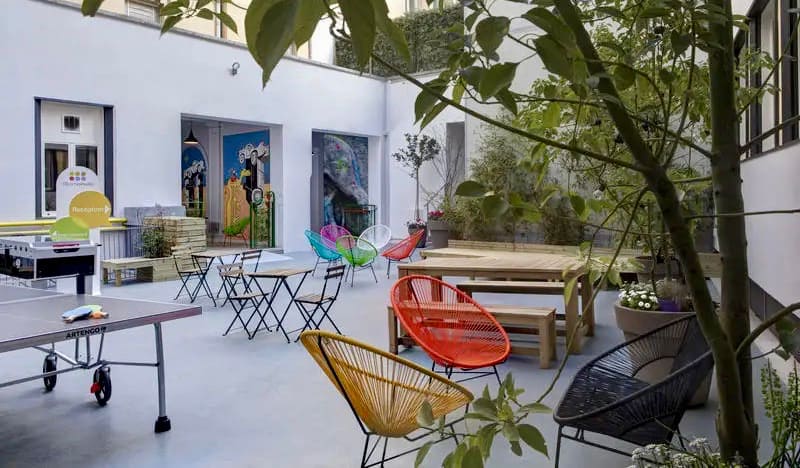 The outdoor courtyard and common area at RomeHello hostel