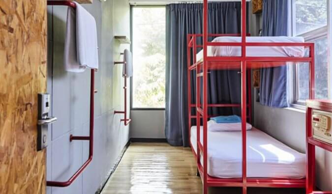 hostel dorm room red bunk beds safe and towel rail