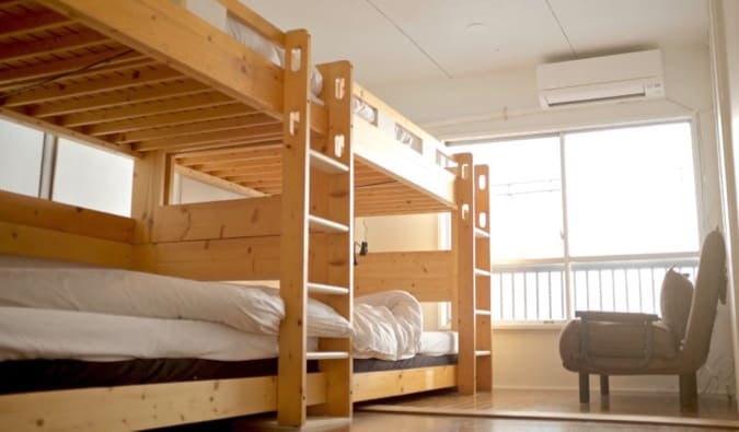 Wooden bunk beds in a dorm room at Hostel Chapter Two in Tokyo, Japan